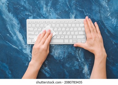 Woman Cleaning Computer Keyboard On Color Background