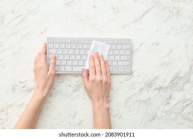 Woman Cleaning Computer Keyboard On Light Background