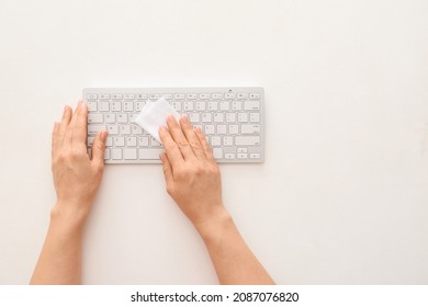 Woman Cleaning Computer Keyboard On White Background