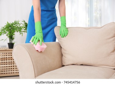 Woman Cleaning Couch With Sponge At Home