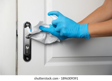 Woman cleaning door handle with antiseptic in office, closeup