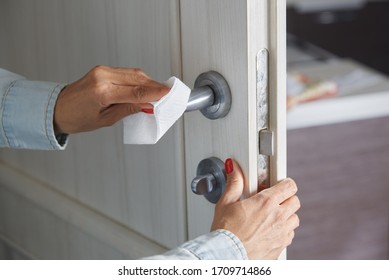 Woman Cleaning The Door Handle With Disinfecting Wipe