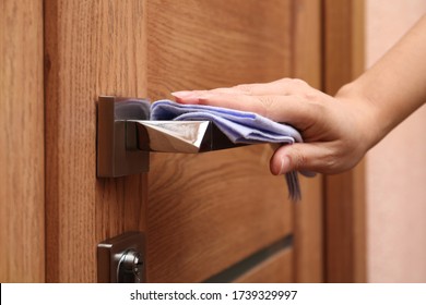 Woman Cleaning Door Handle With Rag Indoors, Closeup