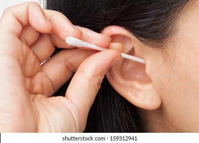 Woman Cleaning Ear Using Cotton Stick