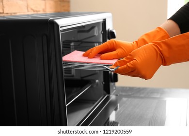 Woman Cleaning Electric Oven With Rag, Closeup