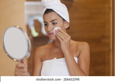 Woman Cleaning Face In Bathroom 