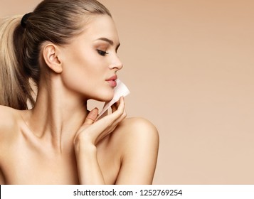 Woman Cleaning Face With Facial Cleansing Wipes, Removing Makeup. Photo Of Woman With Perfect Skin On Beige Background. Beauty Concept