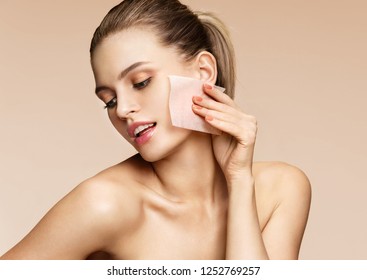 Woman Cleaning Face With Facial Cleansing Wipes, Removing Makeup. Photo Of Woman With Perfect Skin On Beige Background. Beauty Concept