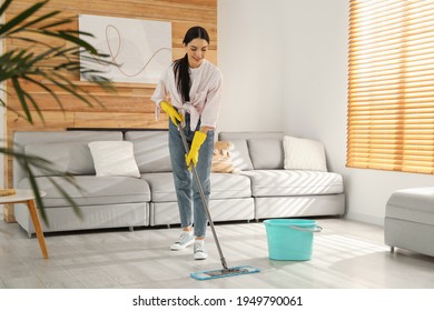 Woman Cleaning Floor With Mop At Home