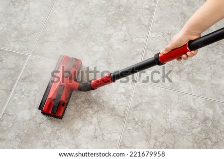 woman cleaning floor steam cleaning into the room