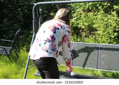 Woman Cleaning Garden Furniture And Getting The Garden Ready For Summer