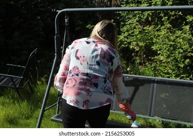 Woman Cleaning Garden Furniture And Getting The Garden Ready For Summer