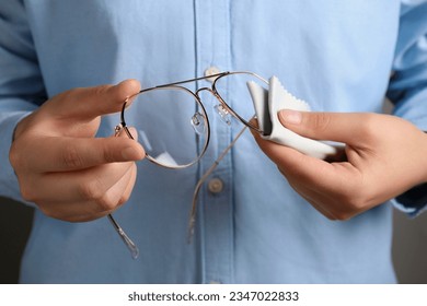 Woman cleaning glasses with microfiber cloth, closeup - Powered by Shutterstock