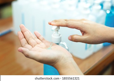Woman cleaning hands with a hand sanitizer gel to prevent coronavirus contamination - Shutterstock ID 1855561321