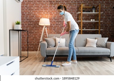 Woman Cleaning The Hardwood Floor With Mop In Face Mask