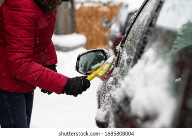 Woman Cleaning Her Car From Snow