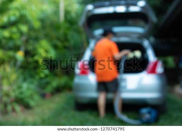 woman cleaning\
her car with a vacuum\
cleaner.