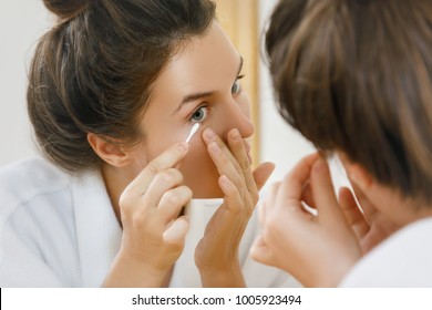 Woman Cleaning Her Eye With A Cotton Swab