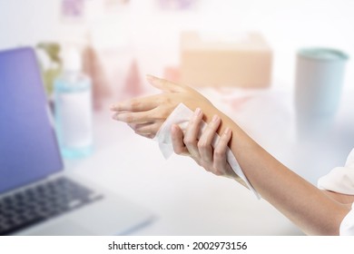 Woman Cleaning Her Hand With Wet Wipe At Office Table Surface With Wet Wipes.