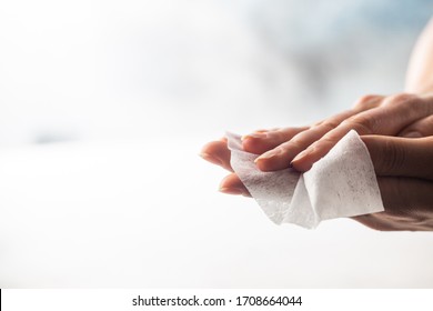 Woman cleaning her hands with wet wipe on a white backgrounds. Hygiene coronavirus protection.