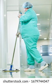 Woman cleaning hospital hall with mop