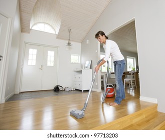 Woman Cleaning The House With The Vacuum Cleaner