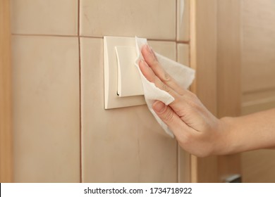 Woman Cleaning Light Switch With Napkin Indoors, Closeup