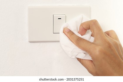 Woman Cleaning Light Switch For Safety