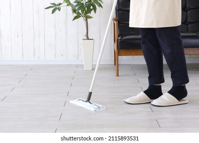 Woman Cleaning Living Room Floor With Mop