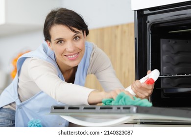 A Woman Is Cleaning The Oven