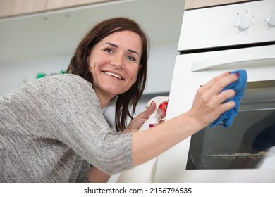 Woman Is Cleaning An Oven Door