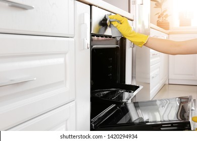 Woman Cleaning Oven At Home