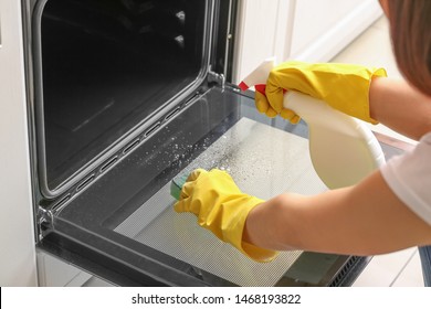 Woman Cleaning Oven At Home