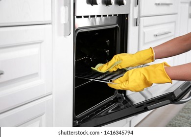 Woman Cleaning Oven In Kitchen