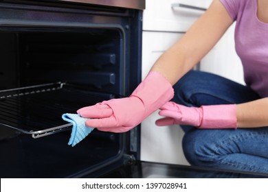 Woman Cleaning Oven Rack With Rag In Kitchen, Closeup