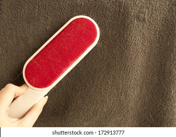 Woman Cleaning Pet Hair With Lint Remover