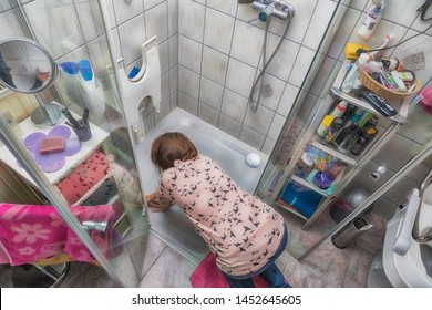 A Woman Is Cleaning A Shower Cubicle