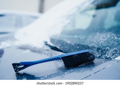 Woman Cleaning Snow Off His Car During Winter Snowfall. Scraping Ice. Winter Window Cleaning.