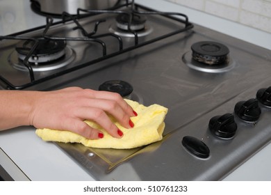 Woman Cleaning Stainless Steel Gas Surface In  The Kitchen At Home