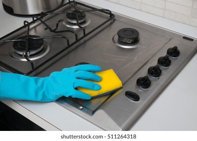 Woman Cleaning Stainless Steel Gas Surface In  The Kitchen At Home