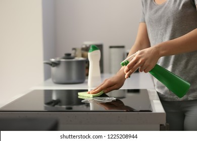 Woman Cleaning Stove In Kitchen