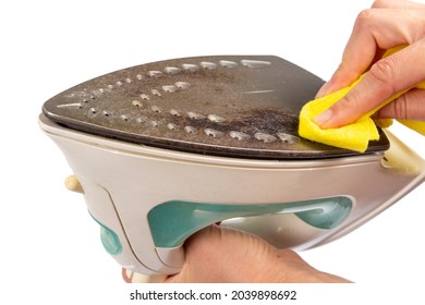 A woman is cleaning the surface of an old dirty iron. The iron has deteriorated. An unsuitable iron will stain clothes. - Shutterstock ID 2039898692