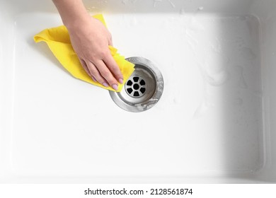 Woman Cleaning White Sink With Wipe, Closeup