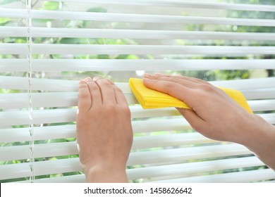 Woman Cleaning Window Blinds With Rag Indoors, Closeup