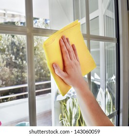 Woman Cleaning A Window With Yellow Cloth