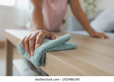 Woman Cleaning And Wiping The Table With Microfiber Cloth In The Living Room. Woman Doing Chores At Home. Housekeeping Concept.