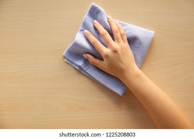 Woman cleaning wooden surface, top view - Powered by Shutterstock