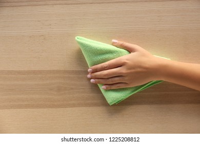 Woman cleaning wooden surface, top view - Powered by Shutterstock