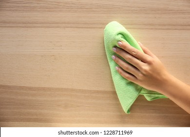 Woman cleaning wooden surface, top view - Powered by Shutterstock