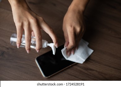 The Woman Cleans The Cell Phone With A Wet Wipe Napkin Stock Photo